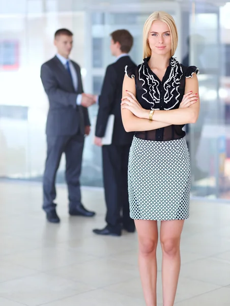 Zakenvrouw permanent op voorgrond in office — Stockfoto