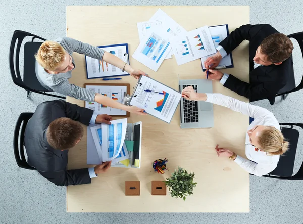 İş adamları iş toplantısında, ofiste oturup tartışıyorlar.