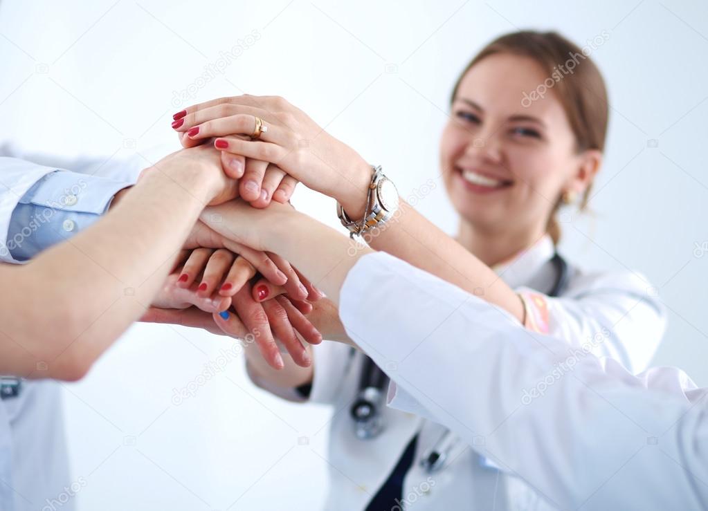 Doctors and nurses in a medical team stacking hands 