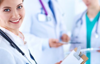 Masada oturan gülümseyen güzel genç bayan doktor.