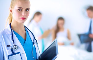 Kadın doktor hastanede dosyayla bekliyor. 