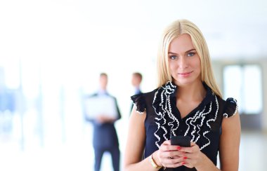 Ofiste cep telefonu kullanan güzel bir iş kadını.