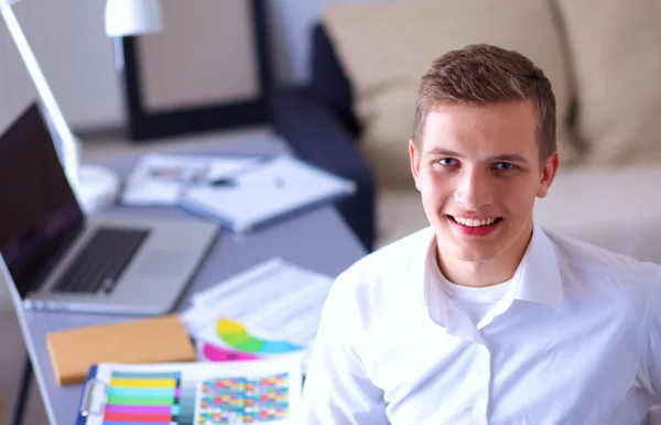 Young businessman working in office, standing near desk — Stock Photo, Image