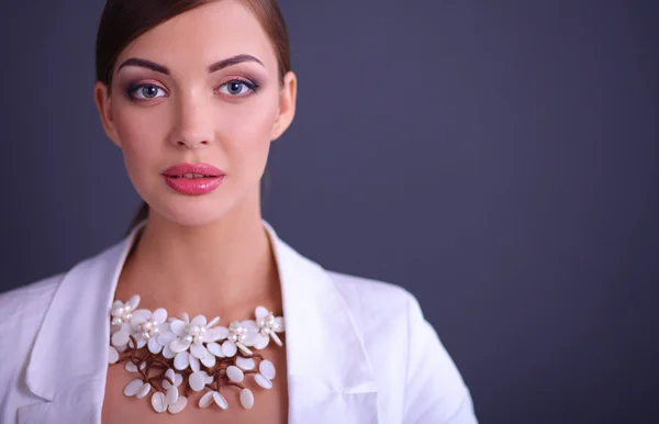 Portrait of young woman with beads, standing on gray background — Stock Photo, Image