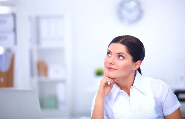 Aantrekkelijke zakenvrouw zit op het bureau in het kantoor — Stockfoto