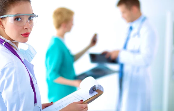 Woman doctor standing with folder at hospital — Stock Photo, Image