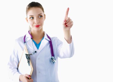 Kadın doktor elinde dosyayla hastanede dikiliyor.