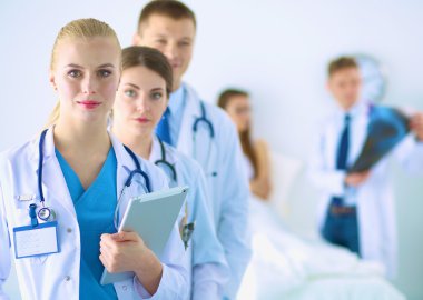 Birlikte ayakta duran bir grup gülümseyen hastane arkadaşının portresi.