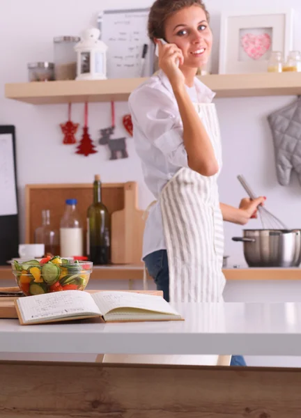 Portrait a smiling woman with phone  in kitchen at home — Stock Photo, Image