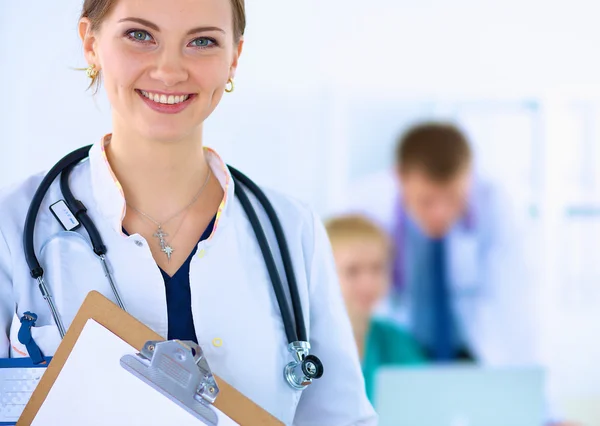 Médico feminino atraente com pasta na frente do grupo médico — Fotografia de Stock