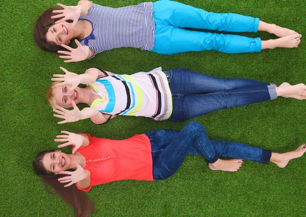 Mujeres jóvenes tumbadas sobre hierba verde —  Fotos de Stock