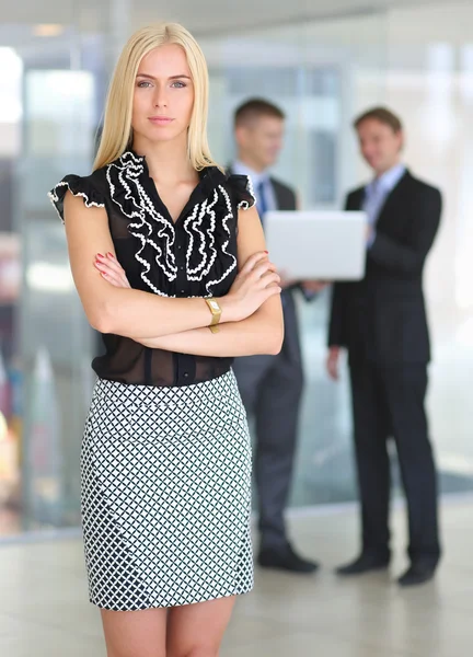 Zakenvrouw permanent op voorgrond in office — Stockfoto