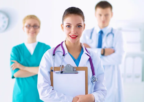 Attractive female doctor in front of medical group — Stock Photo, Image