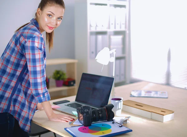 Samica fotograf stojący w pobliżu biurko z laptopa — Zdjęcie stockowe