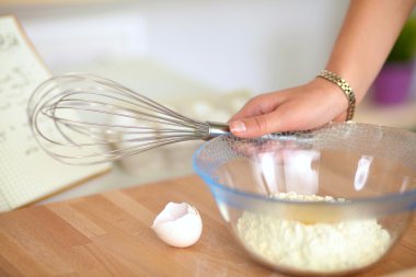 Mutfaktaki genç kadın, arka planda izole edilmiş.