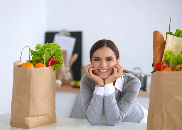 Portrait of a smiling woman cooking in her kitchen sitting — Stock Photo, Image