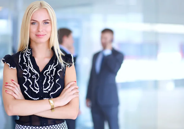 Zakenvrouw permanent op voorgrond in office — Stockfoto