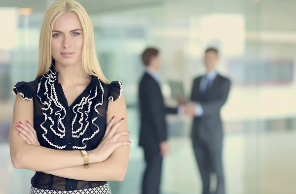 Zakenvrouw permanent op voorgrond in office — Stockfoto