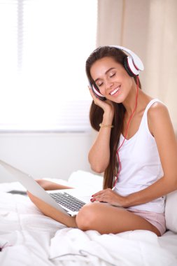 Genç güzel kadın yatakta müzik