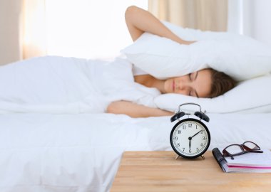 Genç bir kadın sabah alarmını erteliyor.