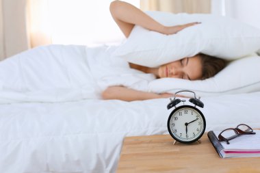 Genç bir kadın sabah alarmını erteliyor.