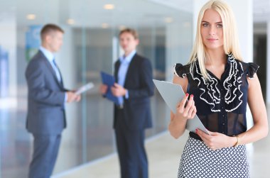 İçinde belgili tanımlık geçmiş meslektaşları ile bir ofiste duran bir güzel ofis çalışanı portresi