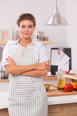 Güzel bir genç kadın mutfağında ayakta