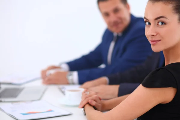 Portret van een mooie zakenvrouw zitten in een kantoor met collega's op de achtergrond — Stockfoto