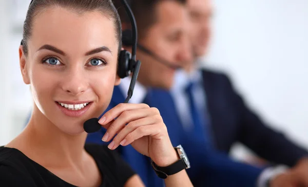 Retrato de mujer de negocios hermosa en auriculares sonriendo con colegas de fondo —  Fotos de Stock