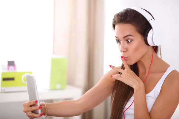 Młoda piękna kobieta w łóżku przy selfie podczas słuchania muzyki — Zdjęcie stockowe