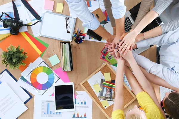 Team of office workers putting their hands together in a symbol of unity — Stock Photo, Image