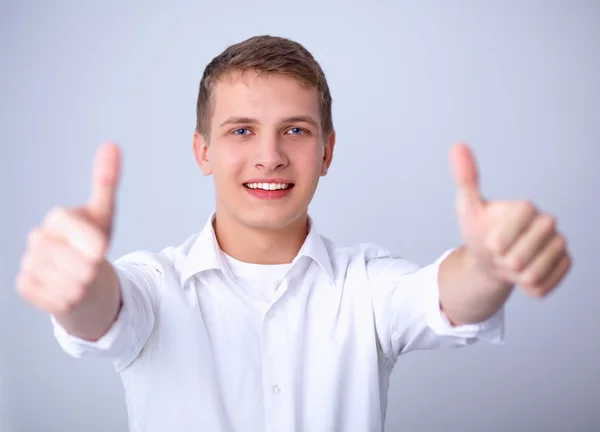Молодой офисный работник показывает большие пальцы вверх — стоковое фото