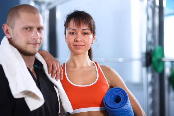 Tiro de um homem e de uma mulher no equipamento do gym antes de um workou — Fotografia de Stock