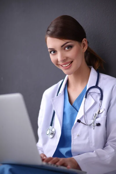 Retrato de um belo médico trabalhando em um laptop — Fotografia de Stock