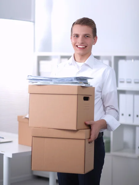 Portrait of a handsome office worker holding a box — Stock Photo, Image