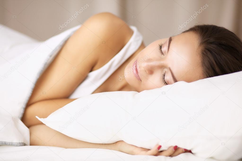 Young beautiful woman lying in bed