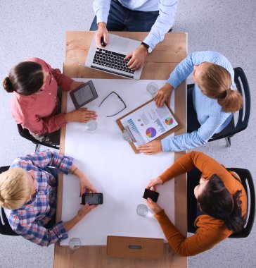 İş adamları iş toplantısında, ofiste oturup tartışıyorlar.