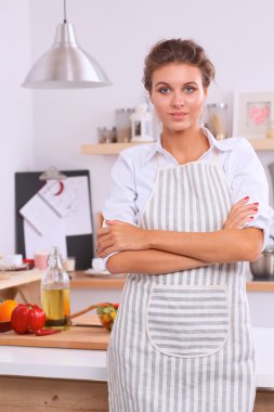 Güzel bir genç kadın mutfağında ayakta