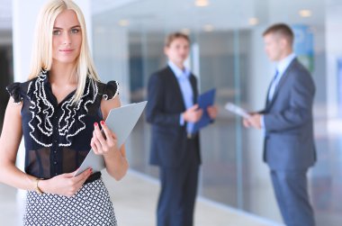 İçinde belgili tanımlık geçmiş meslektaşları ile bir ofiste duran bir güzel ofis çalışanı portresi