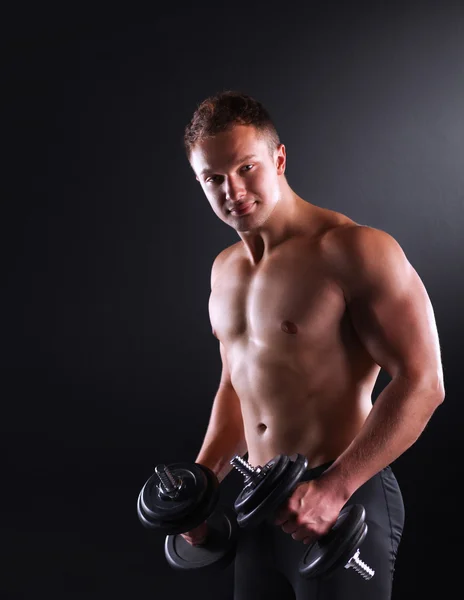 Handsome muscular man working out with dumbbells — Stock Photo, Image