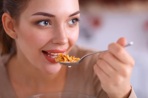 Una giovane donna che cerca cereali nella sua cucina — Foto Stock