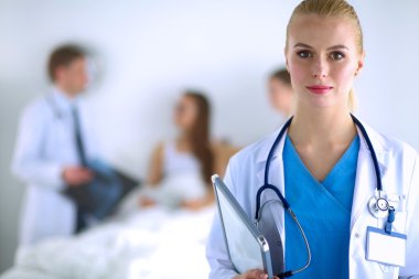 Kadın doktor hastanede steteskopla dikiliyor.