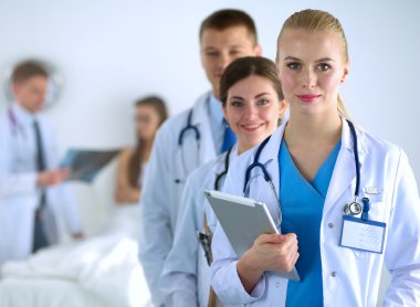 Birlikte ayakta duran bir grup gülümseyen hastane arkadaşının portresi.