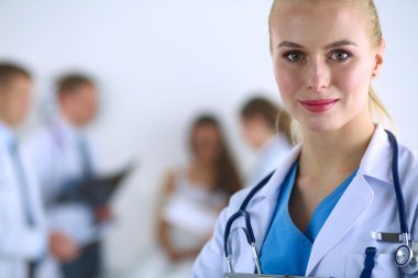 Kadın doktor hastanede steteskopla dikiliyor.