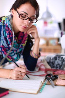 Giysi tasarımcısı kağıt üzerinde kıyafet deseni tasarlıyor