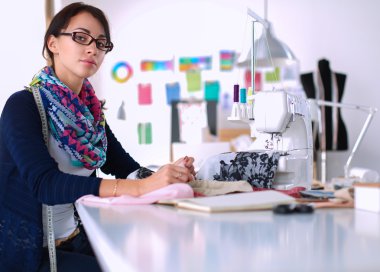 Çalışırken dikiş diken genç bir kadın.