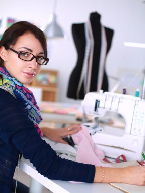 Çalışırken dikiş diken genç bir kadın.