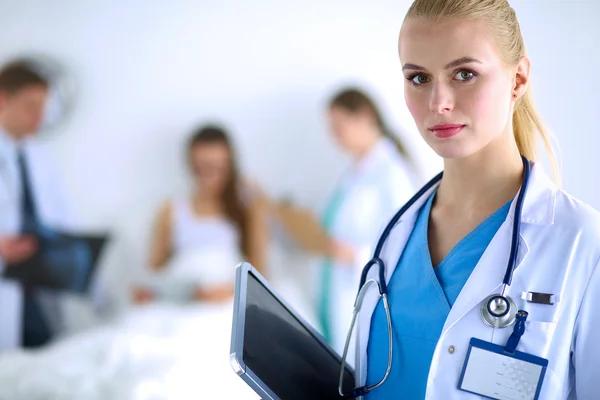 Kvinde læge stående med mappe på hospitalet - Stock-foto