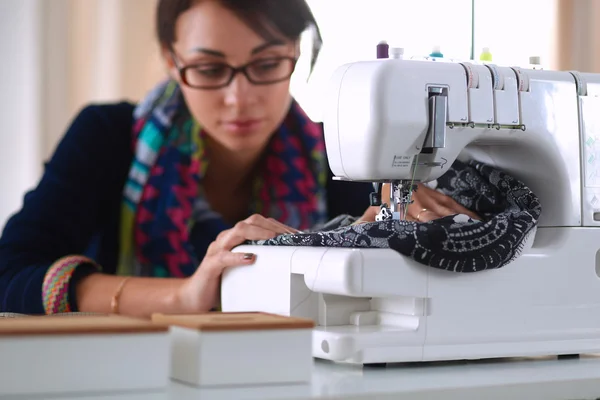 Jeune femme couture assis à son lieu de travail — Photo