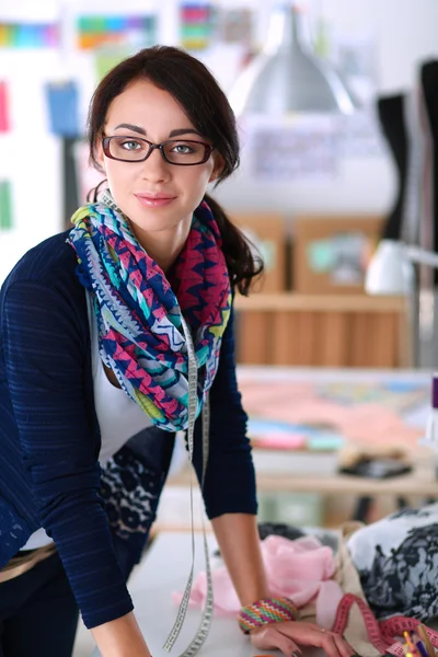 Schöne Modedesignerin steht im Atelier — Stockfoto